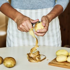 Peeling some potatoes on white table 