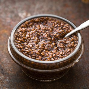 Bowl with flax seeds in water on metal background horizontal