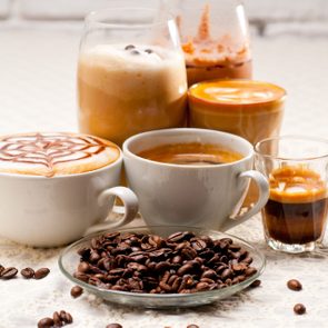 Close-Up Of Coffees With Roasted Coffee Beans Served On Table