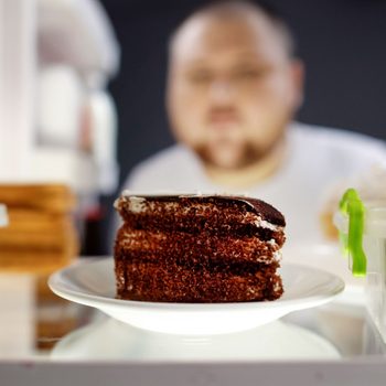 man tempted by cake in the fridge