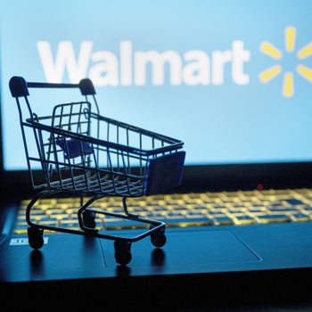 mini shopping cart on a laptop that has the walmart logo in the background