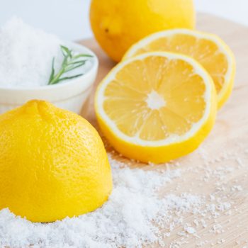 salt and lemon slices on bright backdrop as possible home remedy for corns and calluses